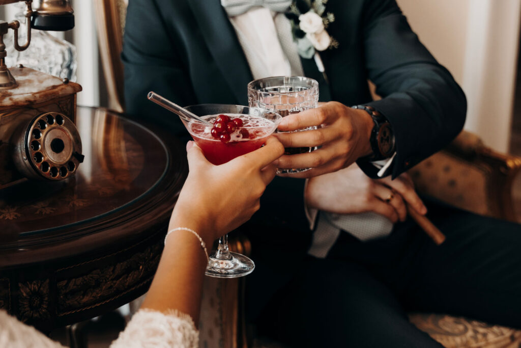 Braut und Bräutigam haben Drinks und stoßen auf ihrer Hochzeit in Ingolstadt miteinander an