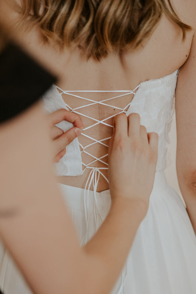 Traurednerin Evylin bindet Brautkleid
