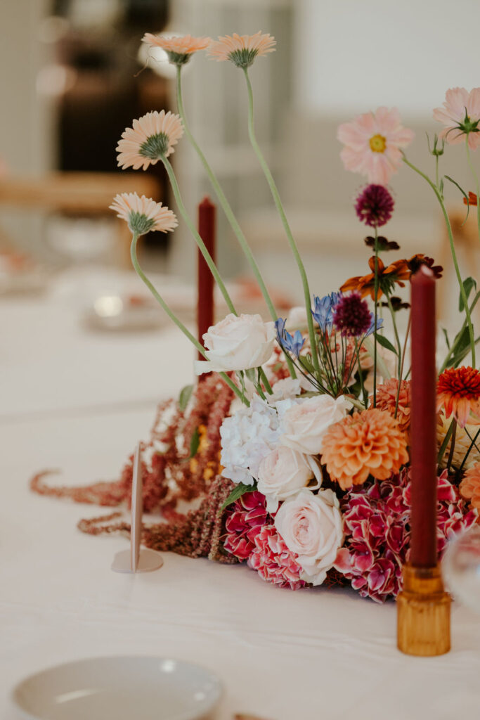 Blumenstrauß auf Tisch mit Kerze im Vordergrund Hochzeit Regensburg mit Evylin Schenk freie Rednerin