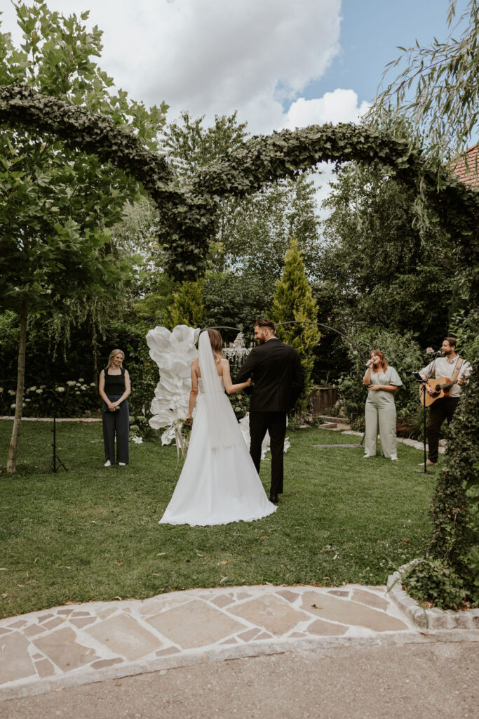 Einzug freie Trauung der multi kulti Hochzeit. Traurednerin und Live Musiker warten auf das Brautpaar