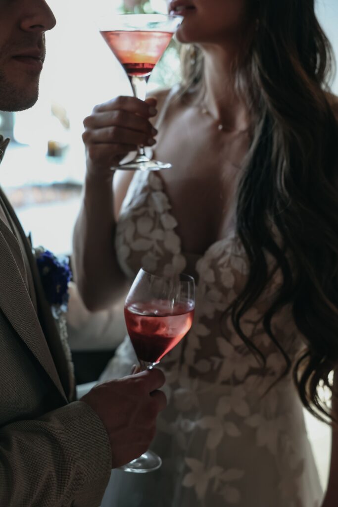 Braut mit Cocktailglas auf Hochzeit in Ingolstadt redet mit Bräutigam über die freie Trauung
