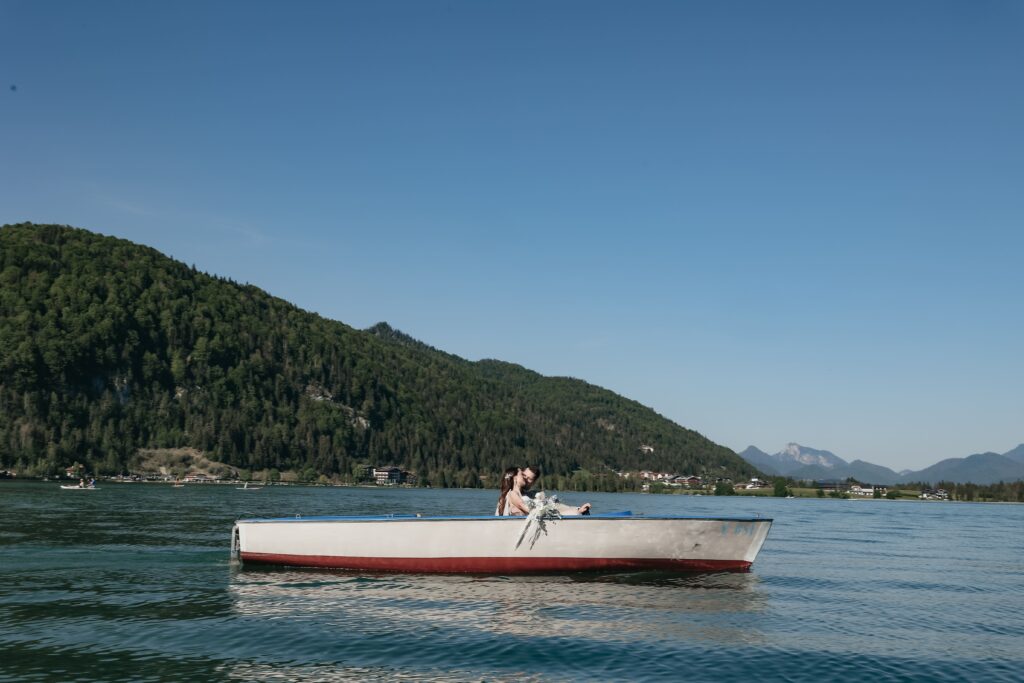 destination wedding bei dem die bride to be und der Bräutigam in einem bayerischen Bergsee Boot fahren