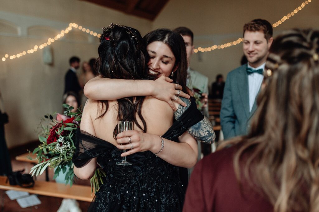 Trauzeugin gratuliert Hochzeitspaar nach ihrer mehrsprachigen freien Trauung in Bayern