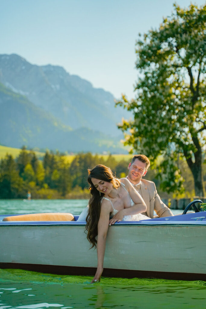 Elopement Wedding am Wasser mit Traurednerin Evylin aus Regensburg, das Paar fährt in einem Boot und die Braut fährt mit der Hand durch das Wasser