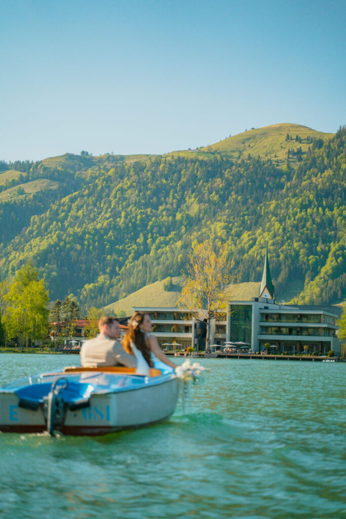 nach der freien Trauung mit ihrem Hochzeitsredner fahren Braut und Bräutigam mit dem Boot auf einem See bei Regensburg