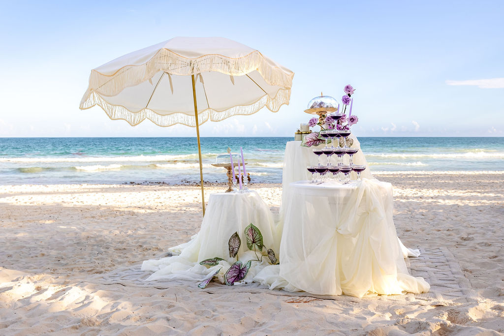 weiße und lila Hochzeitsdekoration am Strand der destination wedding