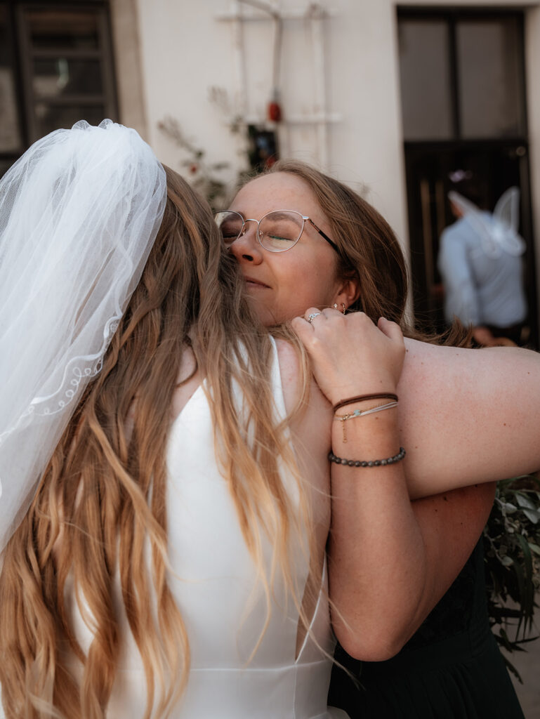 emotionale Braut umarmt ihre beste Freundin und Trauzeugin nach ihrer freien Trauung in Regensburg